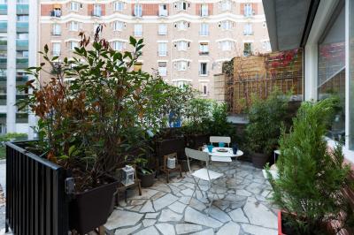 Cuisine étroite avec électroménagers, étagères murales, carrelage au sol et éclairage suspendu.