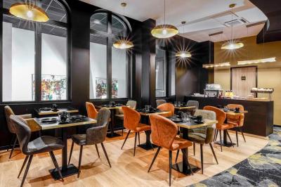 Chambre moderne avec lit double, décor sombre, mur orné d'une grande photo artistique et éclairage tamisé.