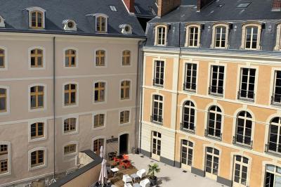 Chambre moderne avec lit double, décor sombre, mur orné d'une grande photo artistique et éclairage tamisé.