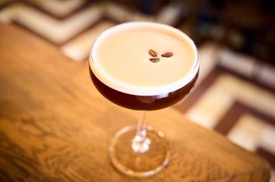 Pot de mousse au chocolat dans un bocal en verre ouvert, posé sur une assiette avec une cuillère en métal.