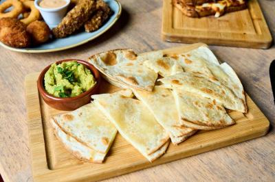 Pot de mousse au chocolat dans un bocal en verre ouvert, posé sur une assiette avec une cuillère en métal.