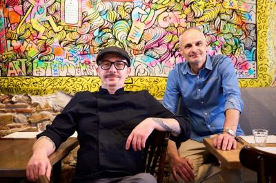 Pot de mousse au chocolat dans un bocal en verre ouvert, posé sur une assiette avec une cuillère en métal.