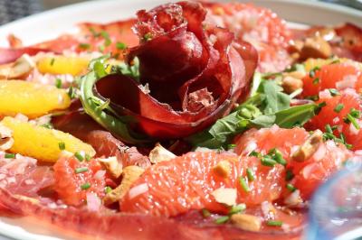 Plat gastronomique composé de viande enroulée, légumes, champignons, sauce brune et garniture de pousses.