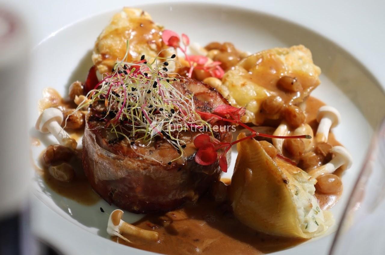 Plat gastronomique composé de viande enroulée, légumes, champignons, sauce brune et garniture de pousses.