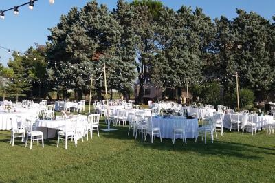 Vue aérienne d'un domaine avec piscine, jardins verdoyants, invités rassemblés et bâtiments en pierre.