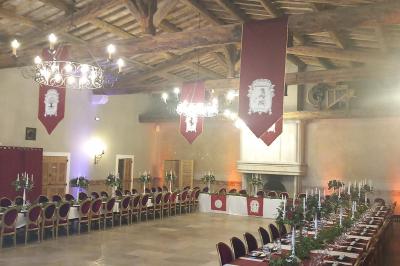 Vue aérienne d'un domaine avec piscine, jardins verdoyants, invités rassemblés et bâtiments en pierre.