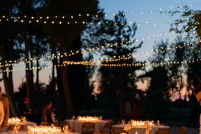 Un couple dansant tendrement lors d'une soirée, entouré de lumières scintillantes en arrière-plan.