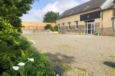 Dortoir avec plusieurs lits superposés en bois, matelas et oreillers, sur un sol carrelé clair.
