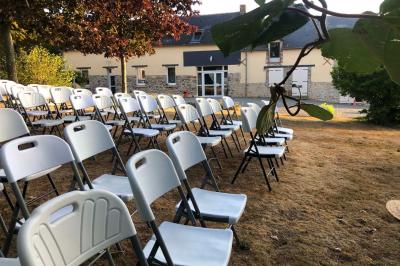Dortoir avec plusieurs lits superposés en bois, matelas et oreillers, sur un sol carrelé clair.