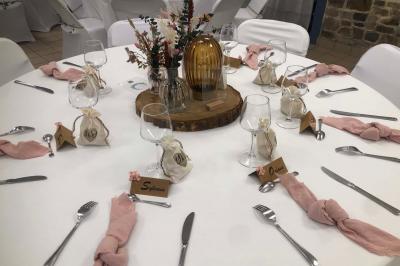 Dortoir avec plusieurs lits superposés en bois, matelas et oreillers, sur un sol carrelé clair.