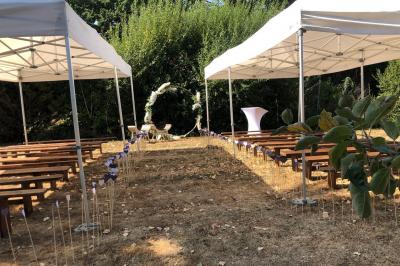 Dortoir avec plusieurs lits superposés en bois, matelas et oreillers, sur un sol carrelé clair.