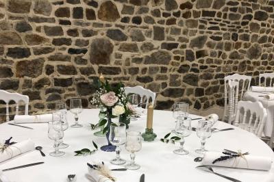 Dortoir avec plusieurs lits superposés en bois, matelas et oreillers, sur un sol carrelé clair.