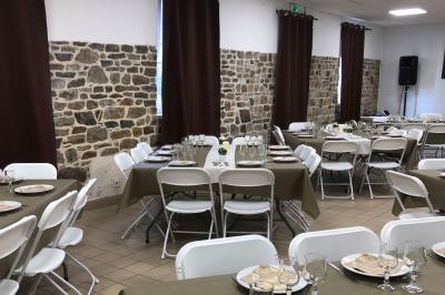 Dortoir avec plusieurs lits superposés en bois, matelas et oreillers, sur un sol carrelé clair.