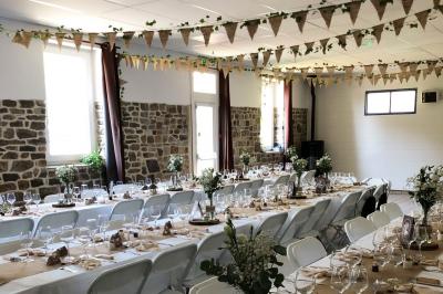 Dortoir avec plusieurs lits superposés en bois, matelas et oreillers, sur un sol carrelé clair.