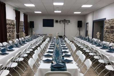 Dortoir avec plusieurs lits superposés en bois, matelas et oreillers, sur un sol carrelé clair.