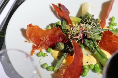 Assiette colorée composée de saumon fumé, courgettes en spirale, fraises et jeunes pousses sur un fond clair.
