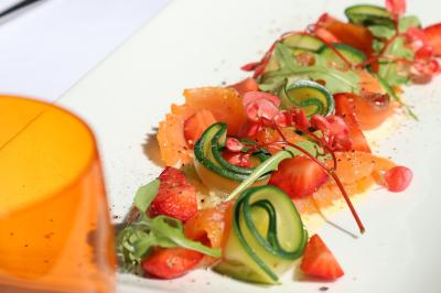 Panier en osier rempli de fruits variés, dont ananas, pommes, oranges et citrons, posé sur une nappe blanche.