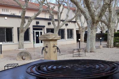 Panier en osier rempli de fruits variés, dont ananas, pommes, oranges et citrons, posé sur une nappe blanche.