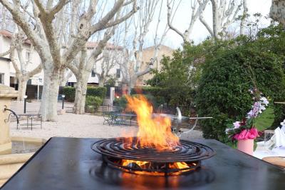 Panier en osier rempli de fruits variés, dont ananas, pommes, oranges et citrons, posé sur une nappe blanche.