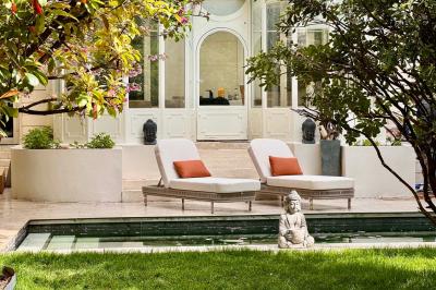 Salle de bien-être avec sauna vitré éclairé en bleu, projecteurs lumineux et ambiance tamisée.