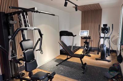 Salle de bien-être avec sauna vitré éclairé en bleu, projecteurs lumineux et ambiance tamisée.