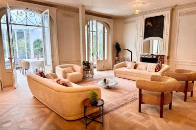 Salle de bien-être avec sauna vitré éclairé en bleu, projecteurs lumineux et ambiance tamisée.