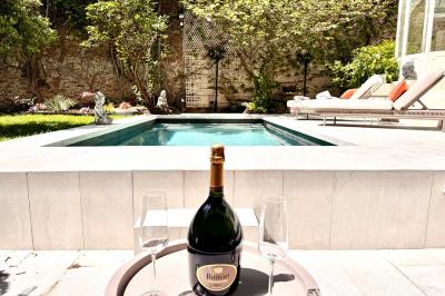 Salle de bien-être avec sauna vitré éclairé en bleu, projecteurs lumineux et ambiance tamisée.