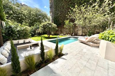 Salle de bien-être avec sauna vitré éclairé en bleu, projecteurs lumineux et ambiance tamisée.