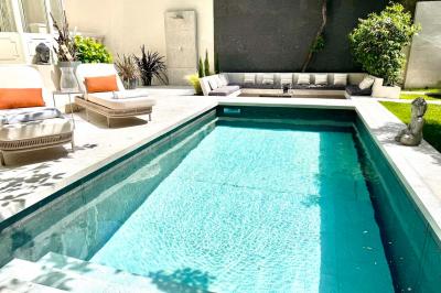 Salle de bien-être avec sauna vitré éclairé en bleu, projecteurs lumineux et ambiance tamisée.