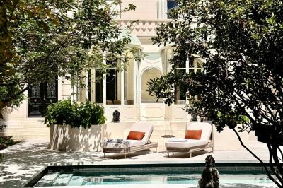 Salle de bien-être avec sauna vitré éclairé en bleu, projecteurs lumineux et ambiance tamisée.