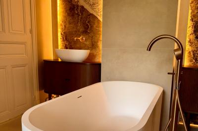 Salle de bien-être avec sauna vitré éclairé en bleu, projecteurs lumineux et ambiance tamisée.