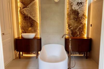 Salle de bien-être avec sauna vitré éclairé en bleu, projecteurs lumineux et ambiance tamisée.