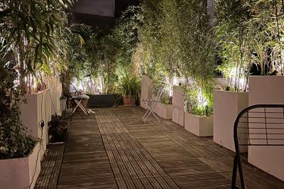 Salle de bien-être avec sauna vitré éclairé en bleu, projecteurs lumineux et ambiance tamisée.
