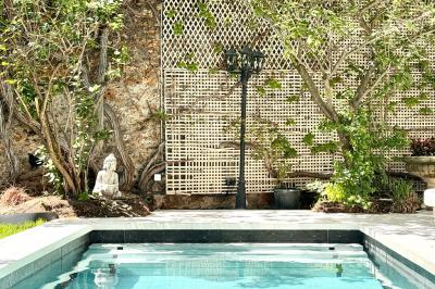 Salle de bien-être avec sauna vitré éclairé en bleu, projecteurs lumineux et ambiance tamisée.