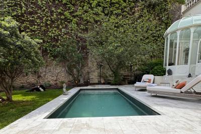 Salle de bien-être avec sauna vitré éclairé en bleu, projecteurs lumineux et ambiance tamisée.