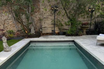Salle de bien-être avec sauna vitré éclairé en bleu, projecteurs lumineux et ambiance tamisée.
