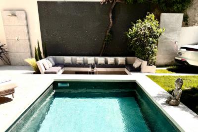 Salle de bien-être avec sauna vitré éclairé en bleu, projecteurs lumineux et ambiance tamisée.