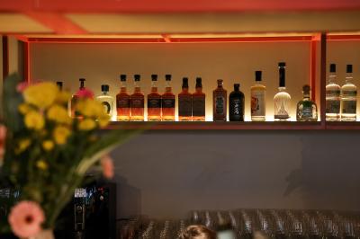 Un couple célèbre son mariage sur une petite scène décorée de voiles et de feuillages, devant une fresque colorée.