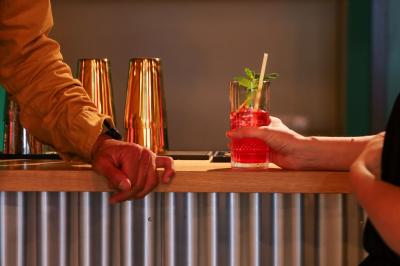 Un couple célèbre son mariage sur une petite scène décorée de voiles et de feuillages, devant une fresque colorée.