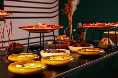 Un couple célèbre son mariage sur une petite scène décorée de voiles et de feuillages, devant une fresque colorée.