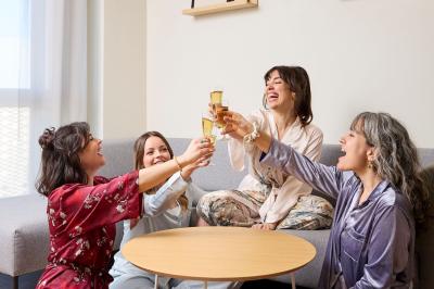 Un couple célèbre son mariage sur une petite scène décorée de voiles et de feuillages, devant une fresque colorée.