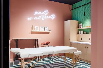 Un couple célèbre son mariage sur une petite scène décorée de voiles et de feuillages, devant une fresque colorée.