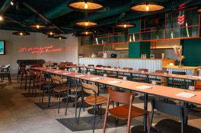 Un couple célèbre son mariage sur une petite scène décorée de voiles et de feuillages, devant une fresque colorée.