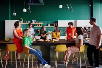 Un couple célèbre son mariage sur une petite scène décorée de voiles et de feuillages, devant une fresque colorée.