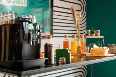 Un couple célèbre son mariage sur une petite scène décorée de voiles et de feuillages, devant une fresque colorée.