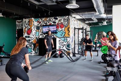 Un couple célèbre son mariage sur une petite scène décorée de voiles et de feuillages, devant une fresque colorée.