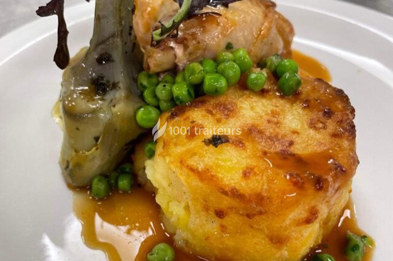 Assiette garnie d'un morceau de viande, d'un gratin doré, d'artichaut, de petits pois et d'une sauce brune.