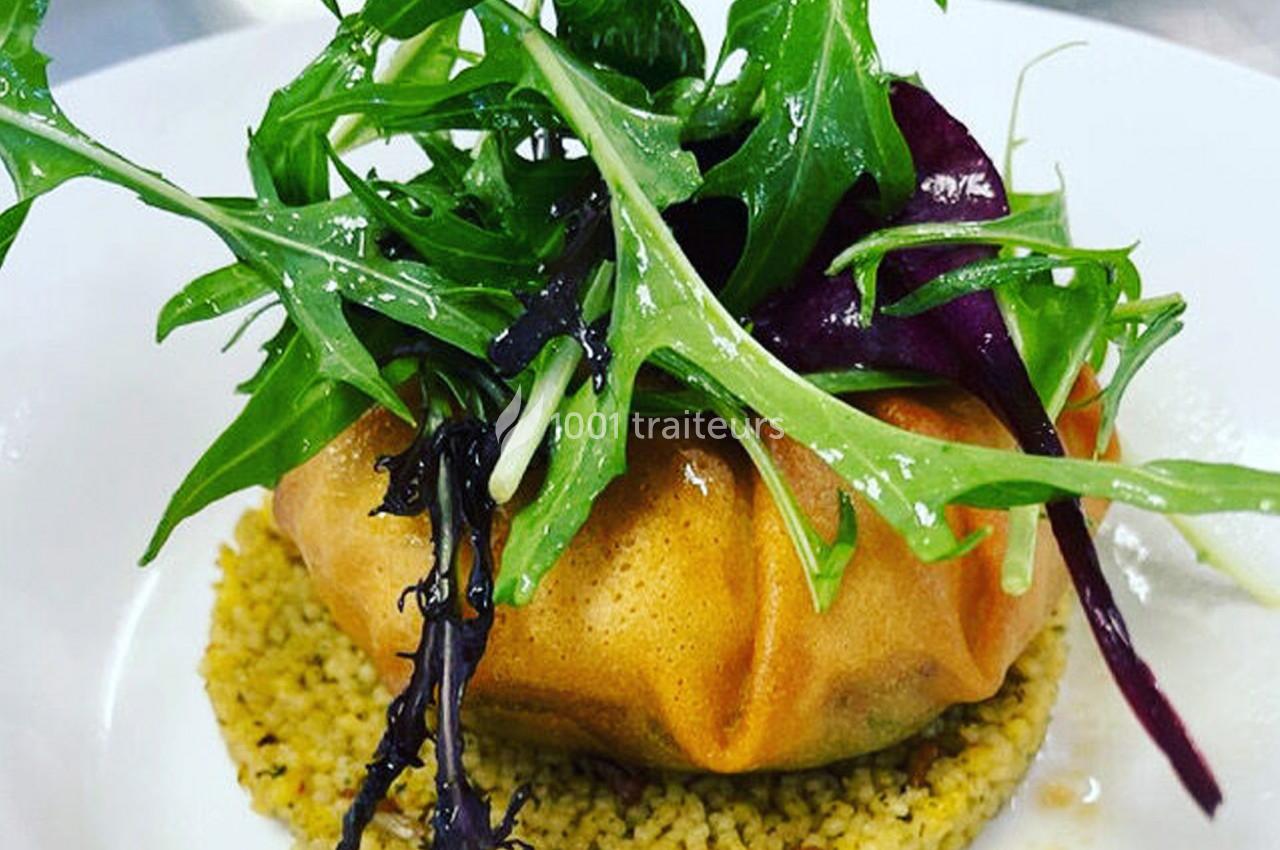 Plat composé d'une feuille croustillante garnie, posée sur du couscous et surmontée de jeunes pousses fraîches.