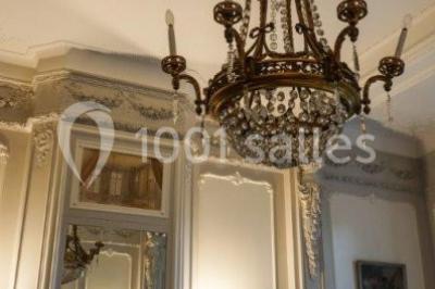 Un petit pont en bois traverse un ruisseau entouré de verdure et de fleurs dans un paysage forestier.