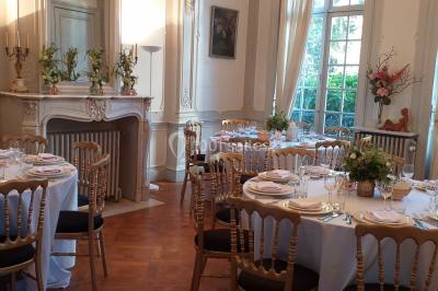 Un petit pont en bois traverse un ruisseau entouré de verdure et de fleurs dans un paysage forestier.